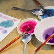 Schälchen mit Farben und Pinseln