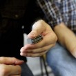 Eine Hand hält Drucksätze, die gespiegelt das Wort "Roman" ergeben