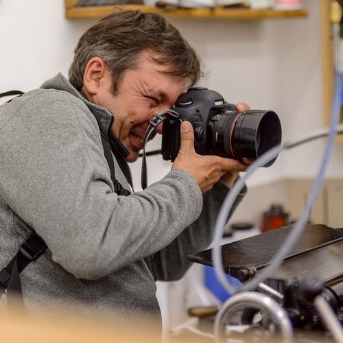 Ein Fotograf schaut durch den Sucher seiner Kamera