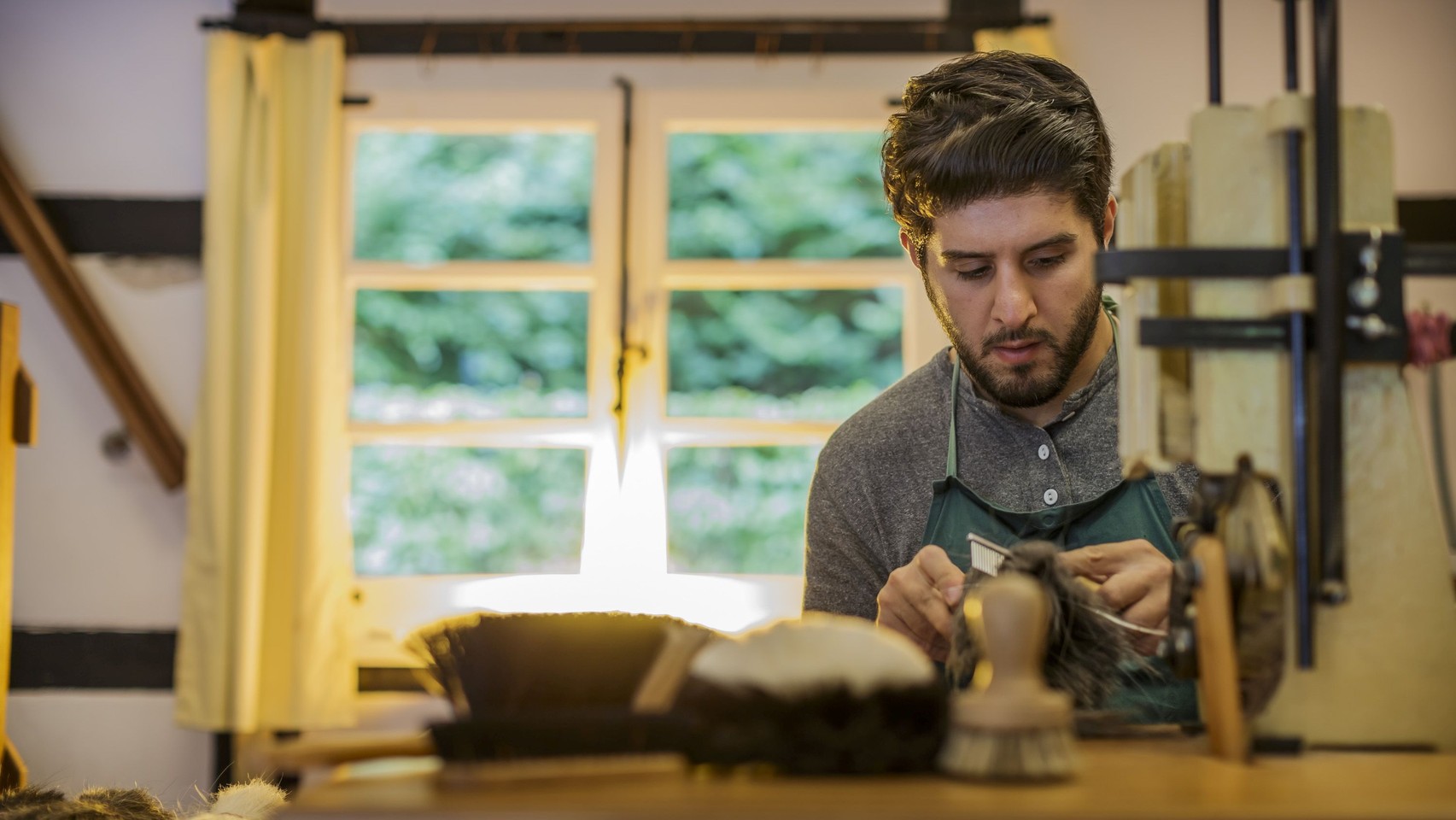 Der Bürstenbinder Arif Özen, kämmt die Borsten für eine neue Bürste
