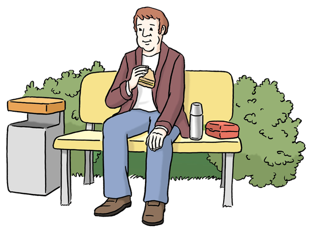 Ein Mann sitzt auf einer Bank und isst etwas