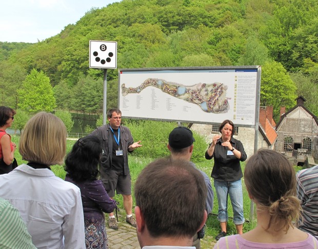 Eine Gruppe steht während einer Führung mit Gebärdendolmetscher vor dem Museumsplan