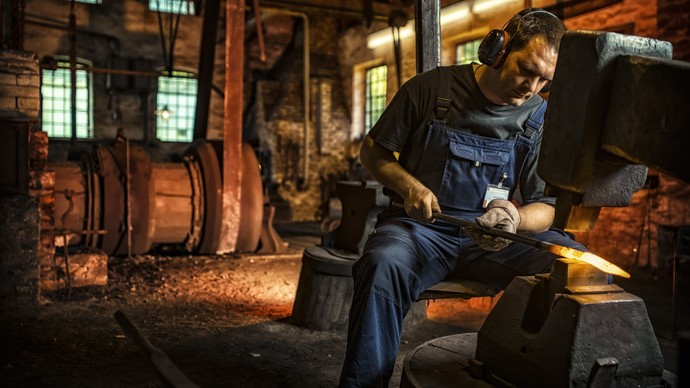 Der Sensenschmied bei der Arbeit