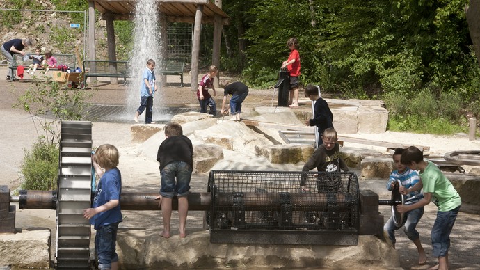 Kinder spielen auf dem Wasserspielplatz