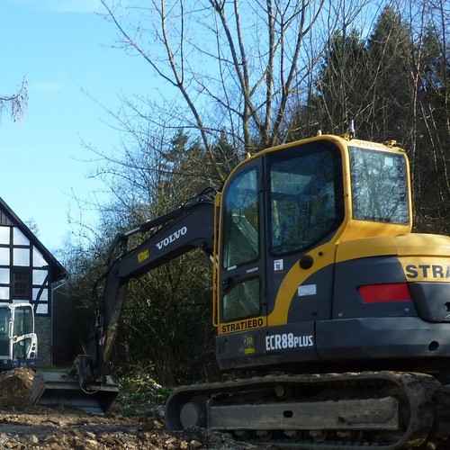 2 Bagger stehen vor einem Fachwerkhaus