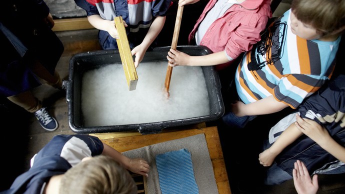 Kinder rühren in einer Schüssel mit weißer Flüssigkeit