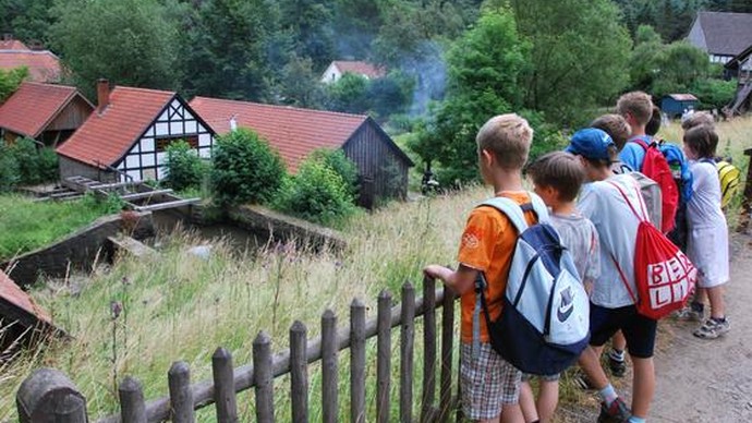 Kinder betrachten eine historische Werkstatt von außen