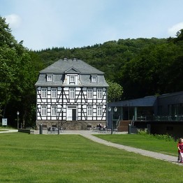 Ein schwarzweißes dreistöckiges Fachwerkhaus mit Mittelrisalit, das ist das Deutsche Schmiedemuseum