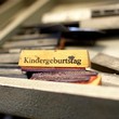 In einer Schublade liegt ein Stempel, mit dem sich das Wort Kindergeburtstag stempeln lässt
