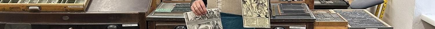 eine gewandete Frau präsentiert historische Drucksachen