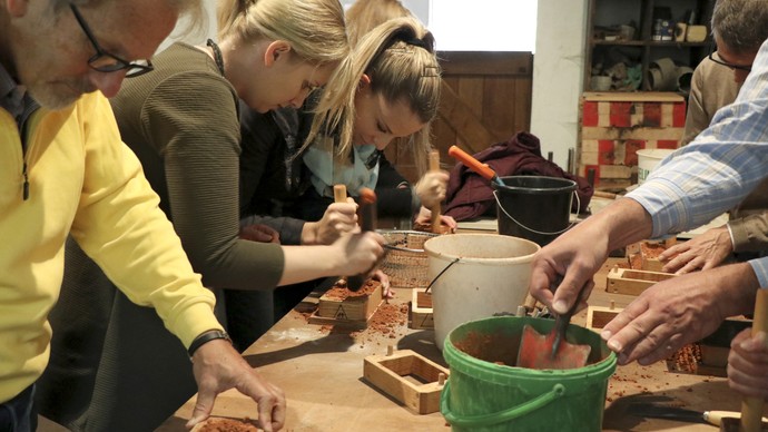 3 Personen arbeiten an einem Werktisch